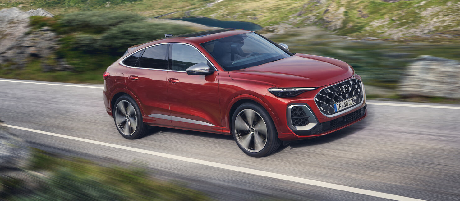 Audi SQ5 Sportback in Rot aus leicht erhöhter Perspektive in Fahrt, kraftvolle Linienführung und athletische Proportionen
