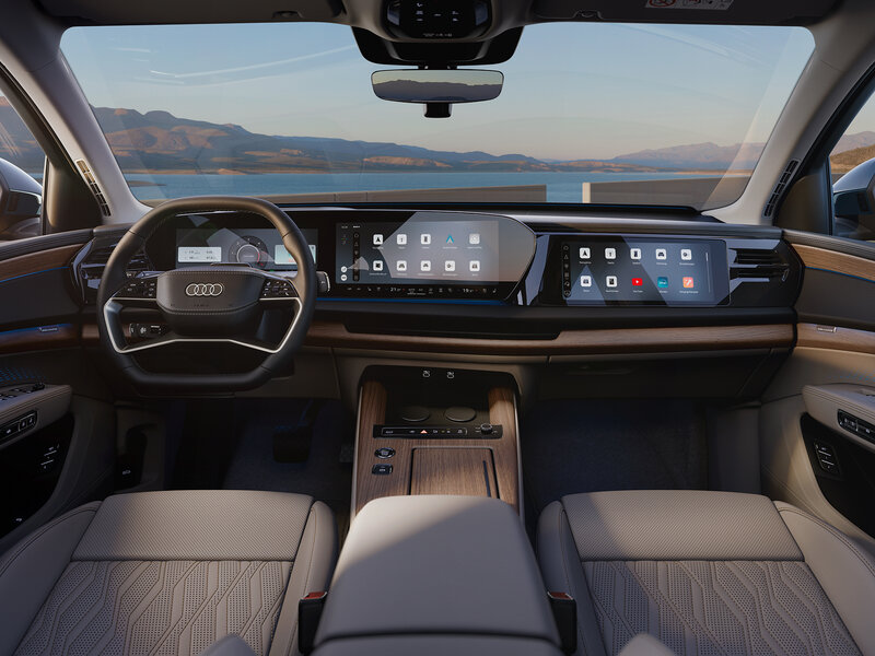 Cockpit des Audi Q7 mit digitalem Kombiinstrument, zentralem Infotainment-Display und Blick über das Armaturenbrett auf die Landschaft draußen