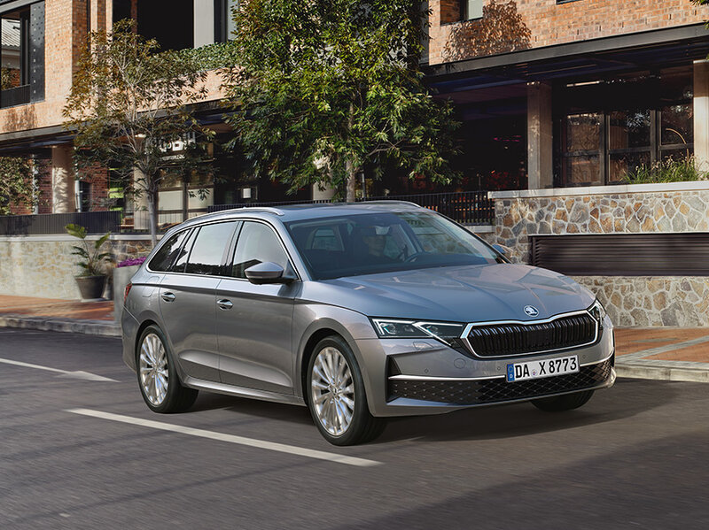 Škoda Octavia Combi in Grau steht an einer Straßenecke vor moderner Wohnarchitektur bei Tageslicht