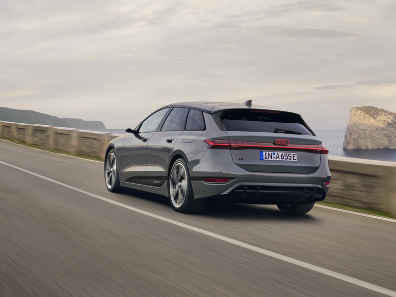 Audi A6 Avant e-tron in Heckansicht bei Fahrt entlang der Küste mit durchgehendem Leuchtenband und sportlicher Linie
