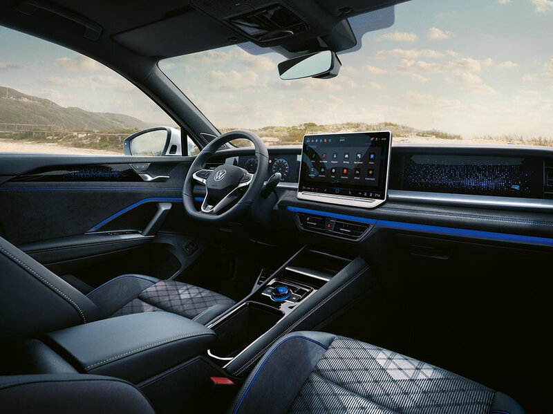 Innenansicht eines Volkswagen Tayron mit digitalem Cockpit, großem Infotainmentdisplay und moderner Mittelkonsole.