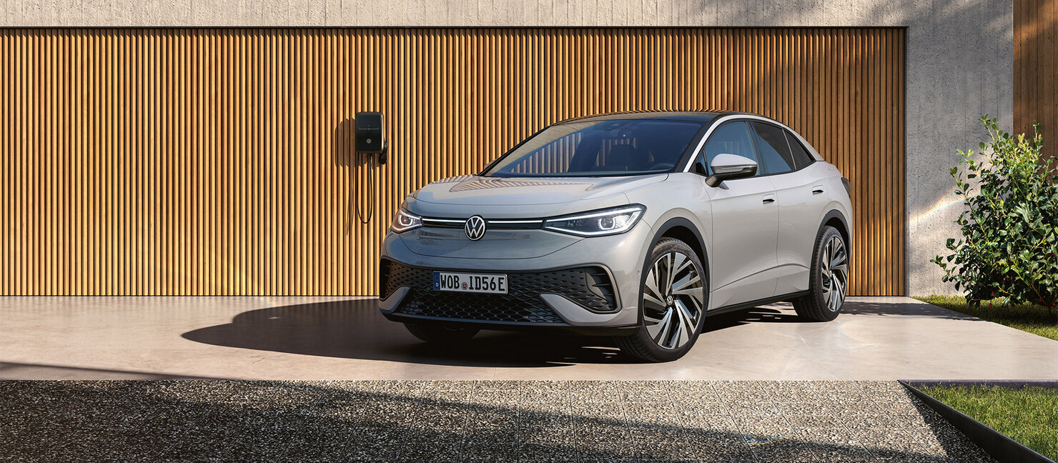 Volkswagen ID.5 in Silber parkt frontal vor moderner Garage mit Wallbox, klare Architektur und Tageslicht