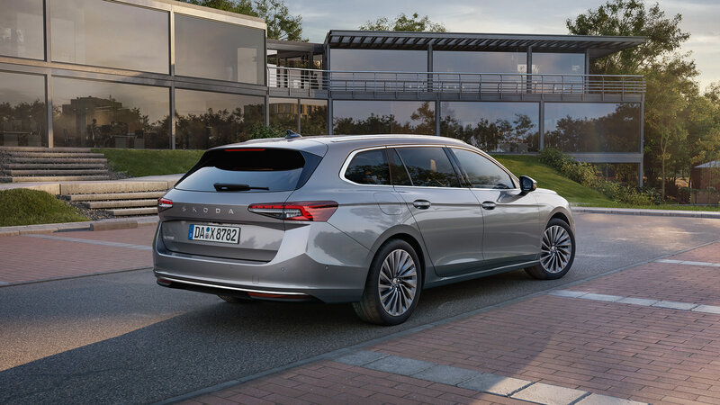 Škoda Superb Combi in Silber-Metallic, geparkt vor einem modernen Gebäude bei warmem Abendlicht.