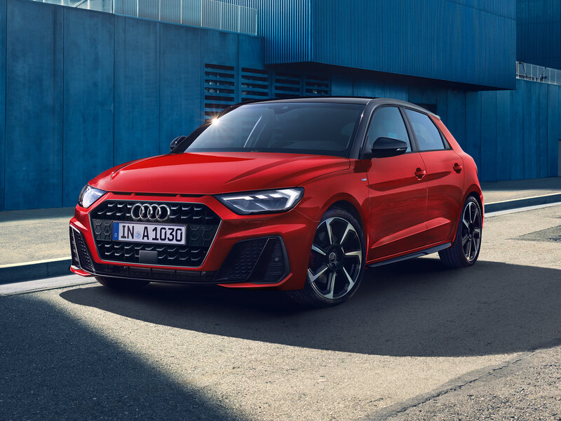 Roter Audi A1 Sportback von vorn, sportliches Exterieur vor urbaner Kulisse mit markantem Singleframe-Grill