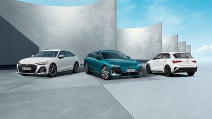 Audi A6 Avant, A6 Avant e-tron und A3 Sportback nebeneinander vor moderner Betonarchitektur in seitlicher Perspektive