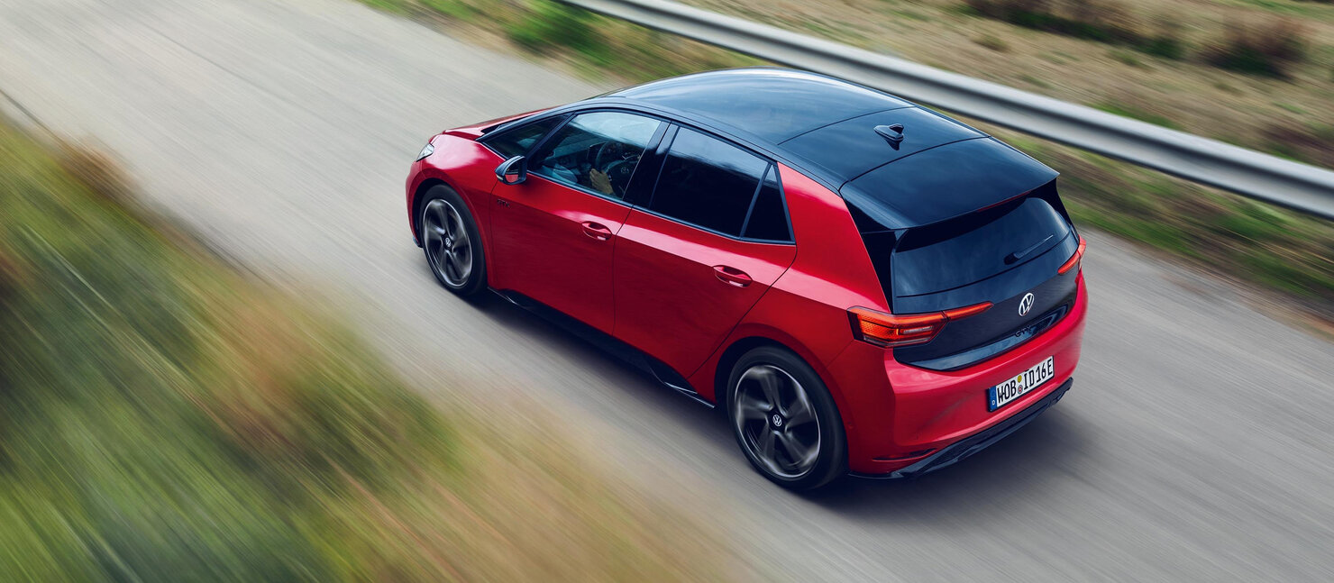 Roter VW ID.3 GTX in schräger Vogelperspektive auf Landstraße, schwarze Dachpartie, sportliche Fahrt