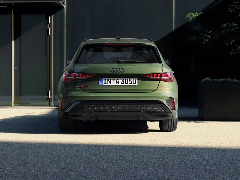 Audi A3 Sportback von hinten vor moderner Architektur, klar gezeichnetes Heck mit LED-Leuchten und breiter Spur