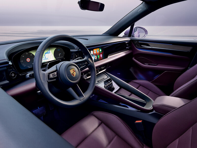 Innenraum eines Porsche mit modernem Cockpit, digitalem Kombiinstrument, zentralem Touchdisplay und Lenkrad aus der Fahrerperspektive.