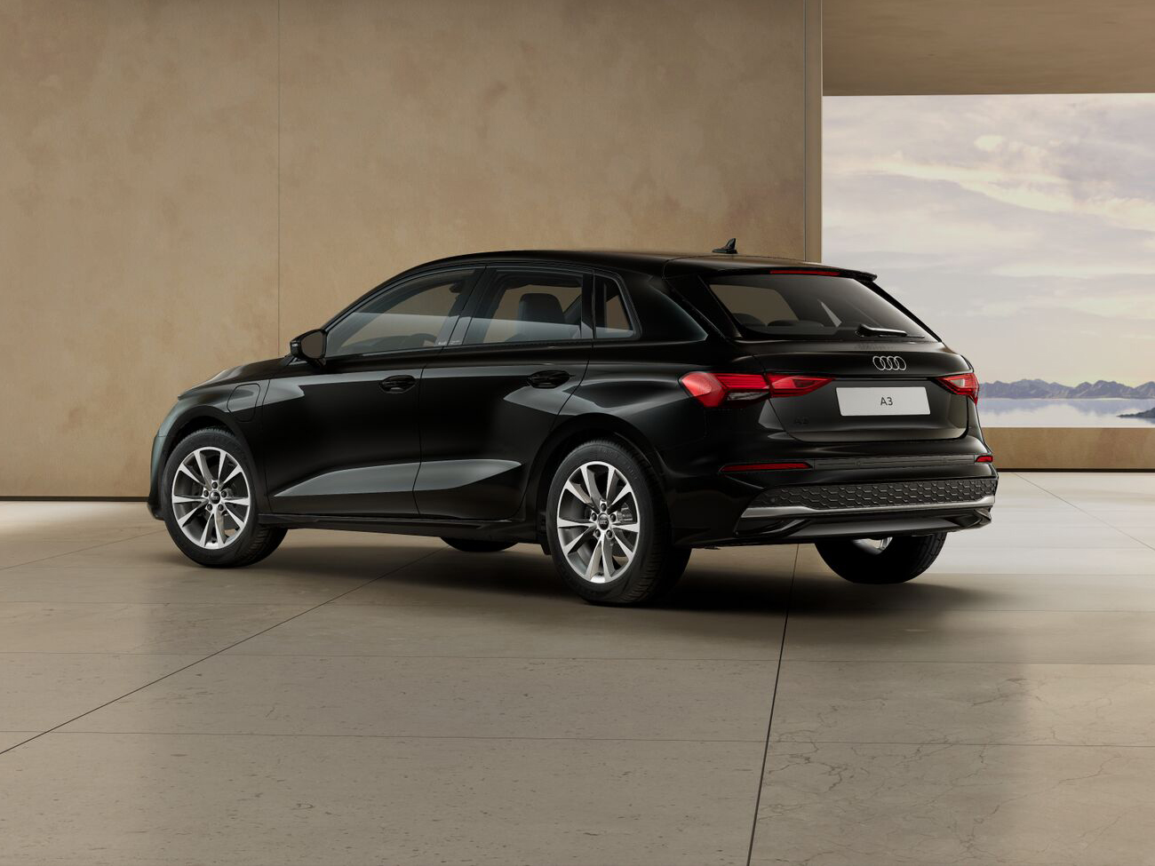 Audi A3 Sportback TFSIe in schwarzer Lackierung aus Heck-Dreiviertel-Perspektive in moderner Architekturhalle geparkt