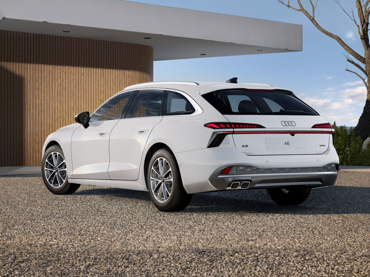 Audi A6 Avant in Heck-/ Seitenansicht parkt vor moderner Wohnhausarchitektur mit Holzfassade auf gepflasterter Einfahrt