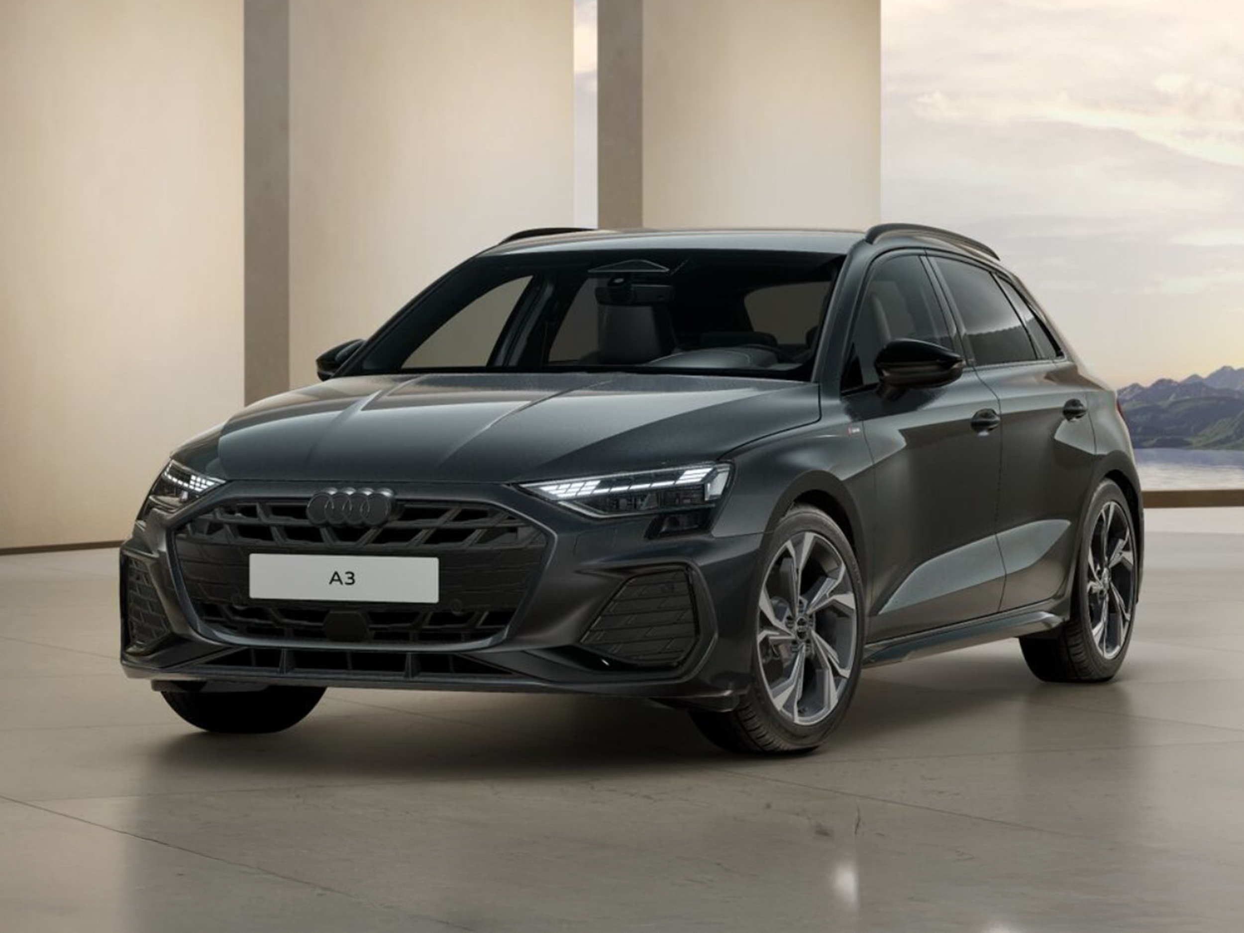 Dunkelgrauer Audi A3 Sportback steht in modernem Innenraum mit Blick auf eine Landschaft im Hintergrund