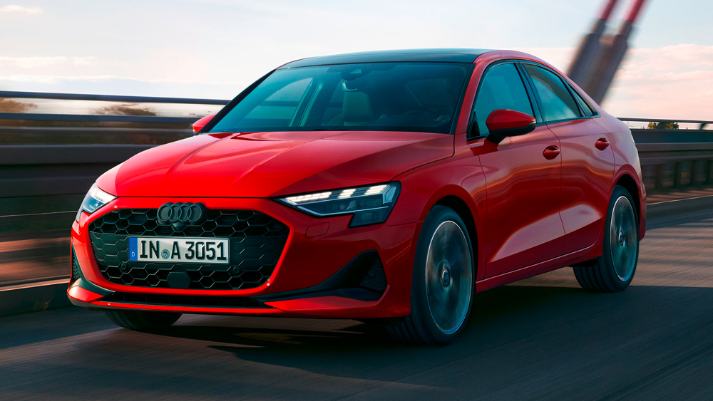 Audi A3 Limousine in Rot fährt dynamisch über eine Brücke, sportliches Design mit markantem Singleframe-Grill