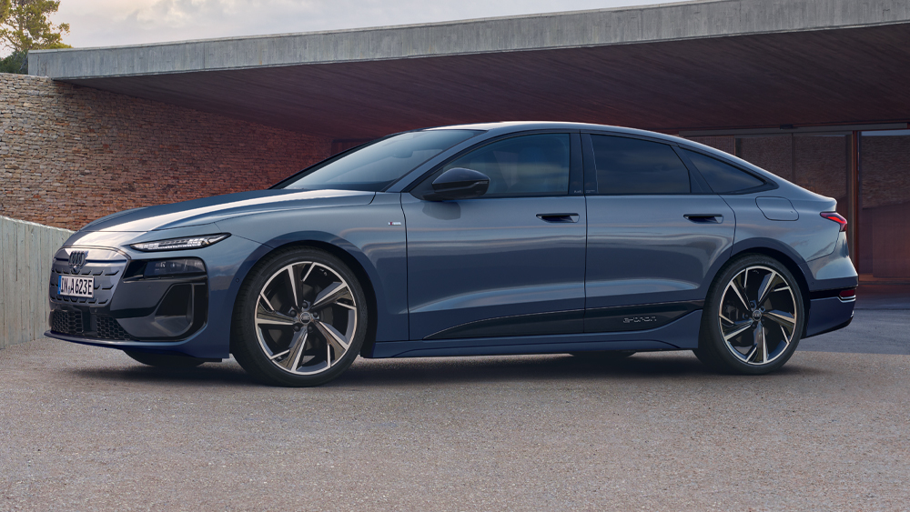 Audi A6 Sportback e-tron in Seitenansicht vor moderner Architektur, elegante Linienführung und coupéhafte Dachlinie betont