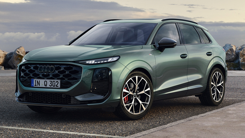 Audi Q3 in Grün, frontal schräg geparkt am Straßenrand, markanter Singleframe-Grill und sportliche SUV-Proportionen