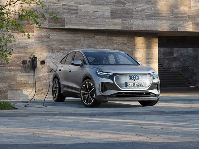 Audi Q4 Sportback e-tron vor modernem Gebäude mit sportlichem Auftritt, breiter Front und aerodynamischer Linie