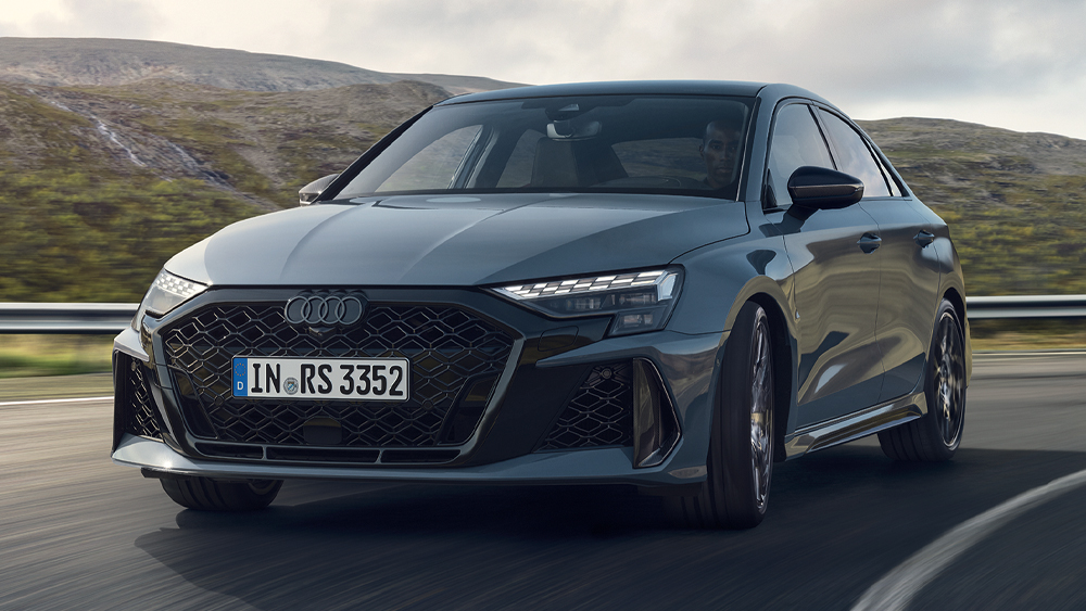 Audi RS3 Limousine in sportlicher Frontansicht auf kurviger Landstraße in alpiner Umgebung