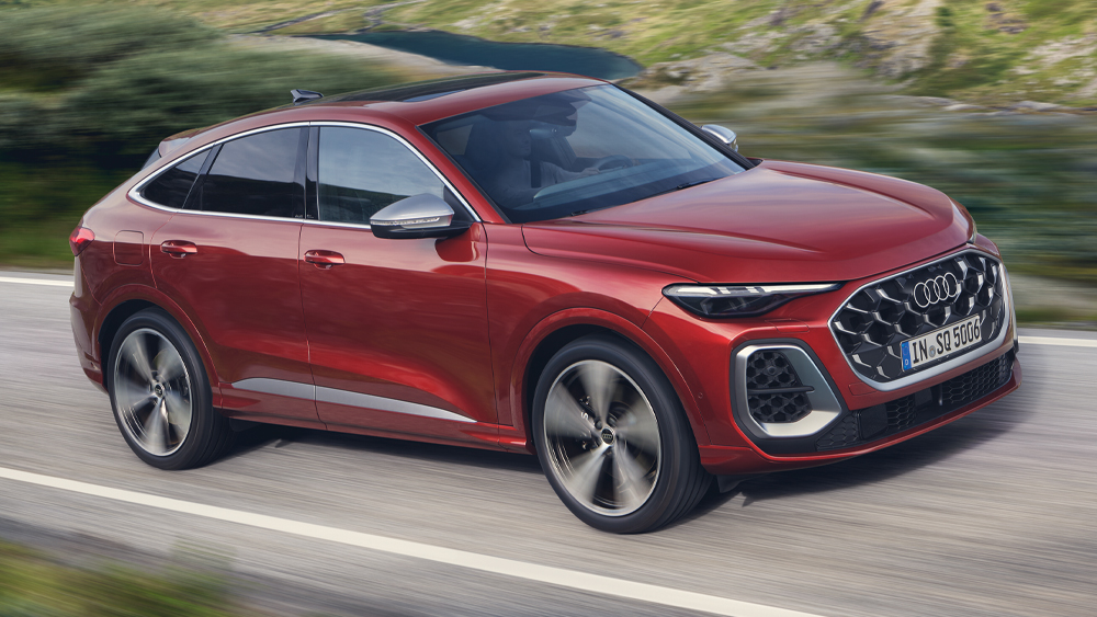 Audi SQ5 Sportback in Rot fährt dynamisch über kurvige Landstraße, sportliches SUV-Coupé mit markantem Singleframe-Grill