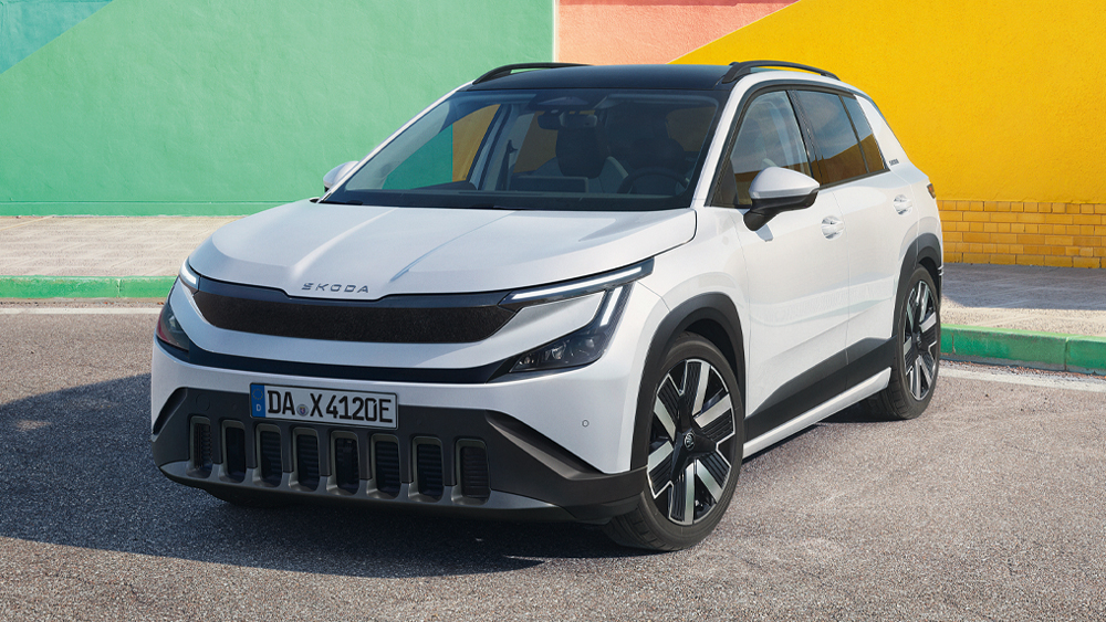 Škoda Epiq in Weiß aus Frontperspektive auf urbaner Straße vor farbigen Gebäudewänden
