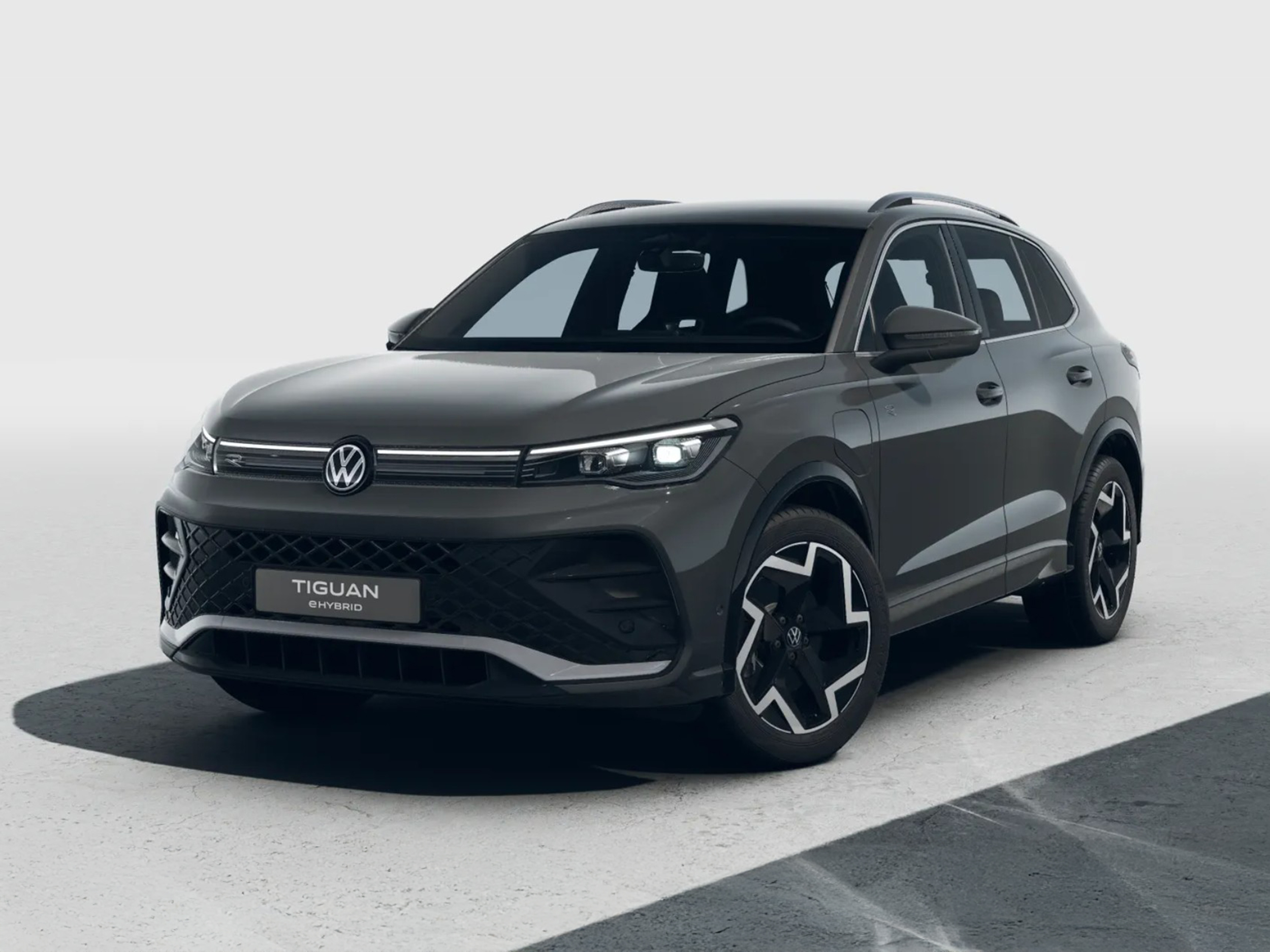 Volkswagen Tiguan eHybrid in Dunkelgrau aus schräger Frontansicht in einem neutralen Studio fotografiert