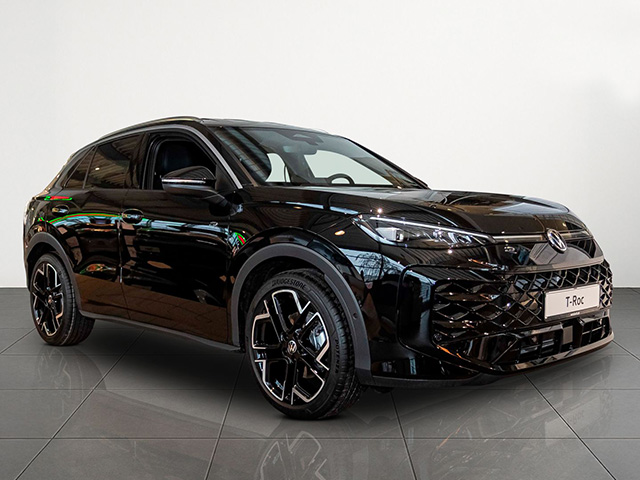 Schwarzer Volkswagen T-Roc in Frontansicht steht in einem hellen Showroom mit Fliesenboden