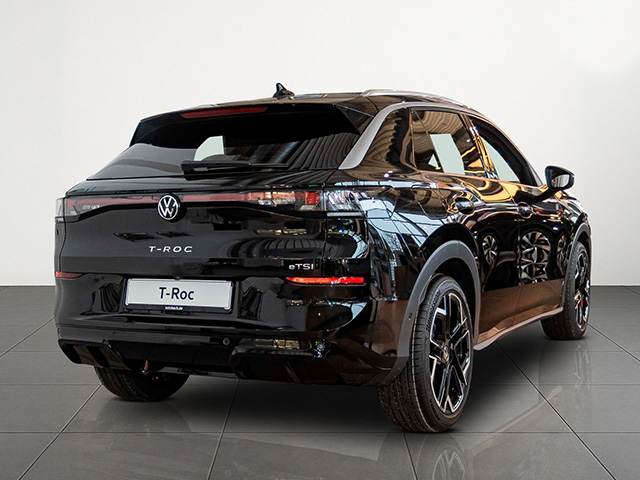 Schwarzer Volkswagen T-Roc in Heckansicht steht in einem hellen Showroom mit Fliesenboden