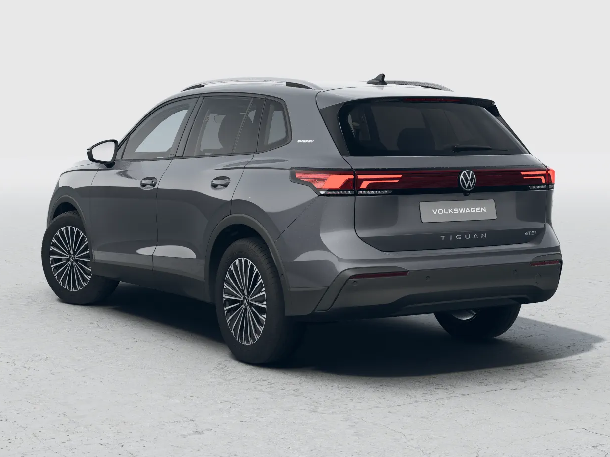 Volkswagen Tiguan Energy in Grau steht in einem hellen Studio, Heckansicht leicht schräg von hinten