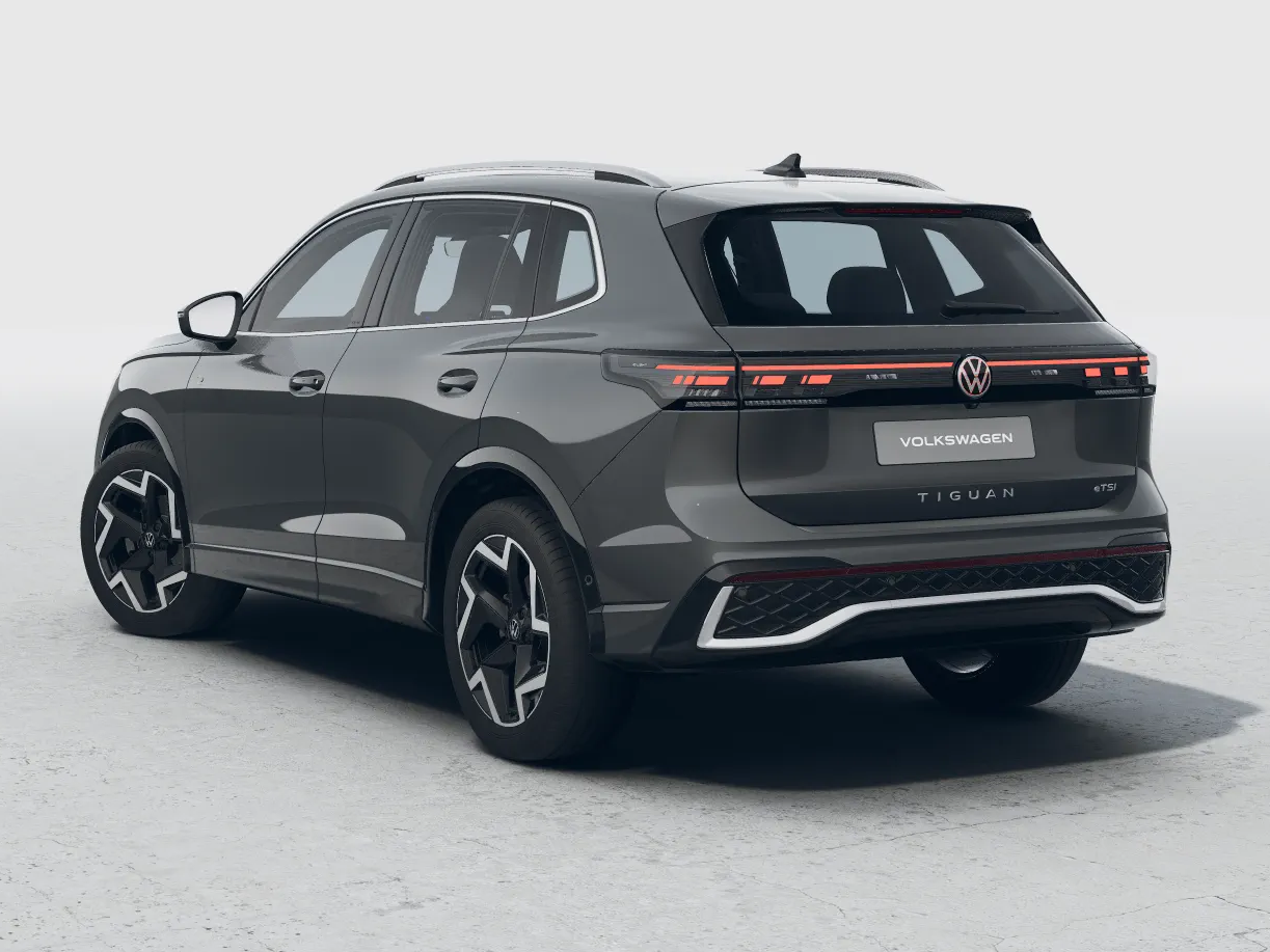 Grauer Volkswagen Tiguan R-Line, Heckansicht im Studio mit markantem Stoßfänger.