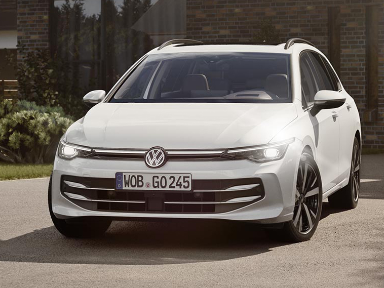 Frontansicht eines weißen Volkswagen Golf Variant in ruhiger Wohnumgebung.