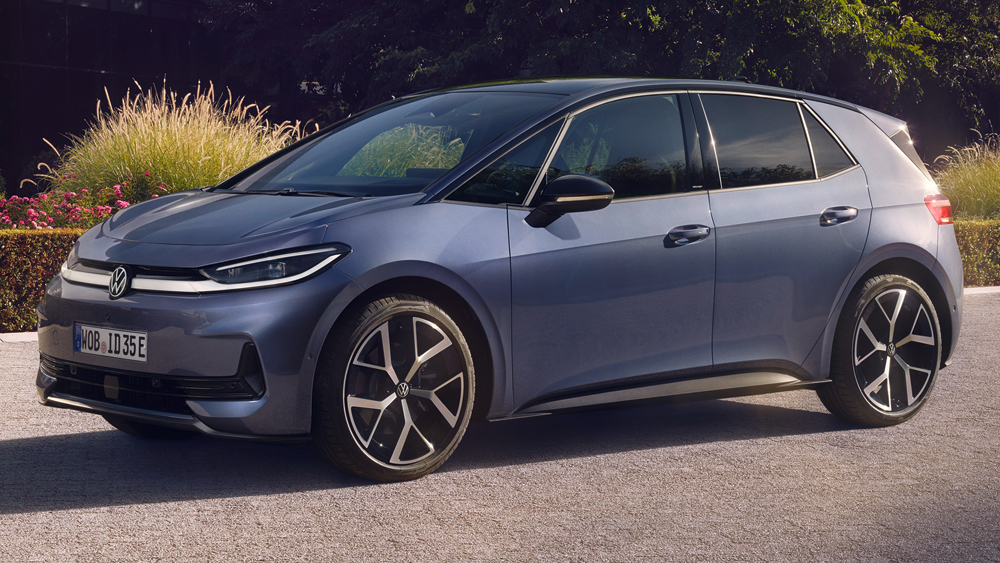 Volkswagen ID.3 Neo in Seitenansicht geparkt am Straßenrand vor bepflanzter Grünfläche bei Abendlicht