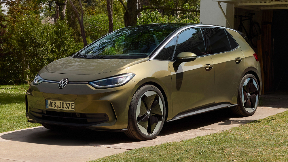 Goldfarbener Volkswagen ID.3 steht auf einer Einfahrt vor einem Wohnhaus, umgeben von Grünflächen