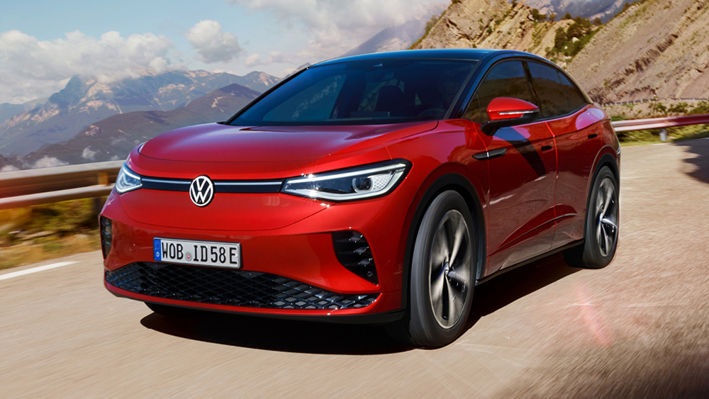 Roter Volkswagen ID.5 GTX fährt dynamisch über kurvige Landstraße mit Berglandschaft im Hintergrund