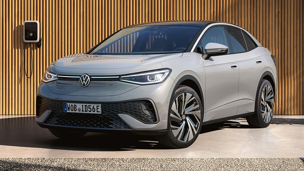 Silberner Volkswagen ID.5 steht vor moderner Garage mit Holzfassade, seitliche Frontansicht in ruhiger Wohnumgebung