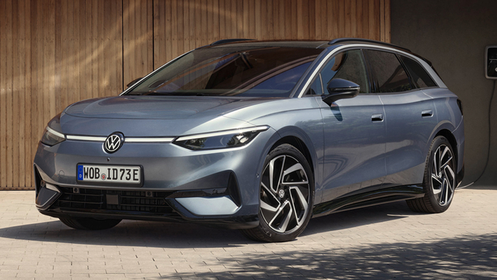 Volkswagen ID7 Tourer in Grau, sportlich geparkt vor moderner Holzfassade mit klaren Linien und Ladepunkt