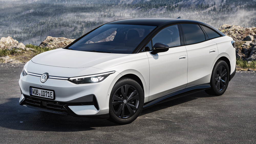 Weißer Volkswagen ID.7 schräg von vorn auf dunklem Untergrund vor bergiger Landschaft in dynamischer Perspektive