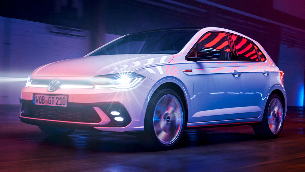 Volkswagen Polo GTI in Weiß fährt durch eine beleuchtete Halle mit blau-roter Lichtstimmung