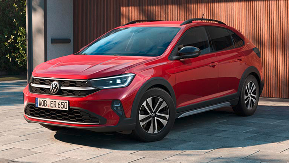 Roter Volkswagen Taigo steht vor modernem Gebäude, mit markantem Frontdesign und erhöhter Crossover-Silhouette