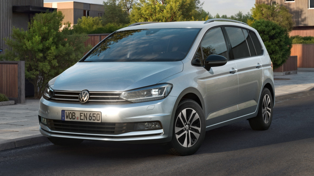 Volkswagen Touran in Silber, schräg von vorn in Wohngebiet geparkt, zeigt kompaktes Design und Familienvan-Charakter